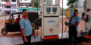 DISTRICT KATNI, INDIA - 23 Ağustos 2019: İki Asyalı yakıt pompası personeli Hindistan petrol istasyonunda başlık tutuyor.