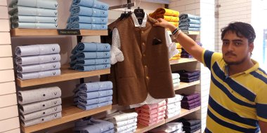 DISTRICT KATNI, INDIA - 18 Eylül 2019: Hintli bir satıcı Hint festivali pazarında elbise mağazasında parti erkek giysisi sergiledi.