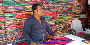 DISTRICT KATNI, INDIA - 18 Eylül 2019: Hintli bir esnaf Hint festivali pazarında kadın giysileri satıyor.