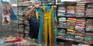 DISTRICT KATNI, INDIA - 18 Eylül 2019: Hint festivali pazarında kadın giysisi satan Hintli bir satıcı.