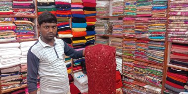 DISTRICT KATNI, INDIA - SEPTEMBER 18, 2019: Hintli bir esnaf Hindistan festivali pazarında kadın kıyafetlerini tanıtıyor.