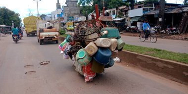DISTRICT KATNI, INDIA - 18 Eylül 2019: Hintli bisikletçi yolda taşınırken çöp ögesini aşırı yükledi.