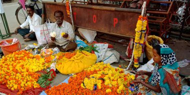 DISTRICT KATNI, Hindistan - 24 Eylül 2019: Kadife çiçeği çelengi sunan Hintli bir satıcı Asya pazarındaki yerel dükkanda.