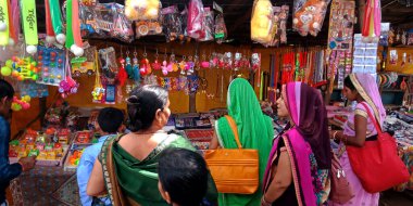 DISTRICT KATNI, INDIA - 13 Ekim 2019: Hintli kadınlar köy bölgesindeki Hindu tapınağı caddesi dükkanından moda ürünler alıyorlar.