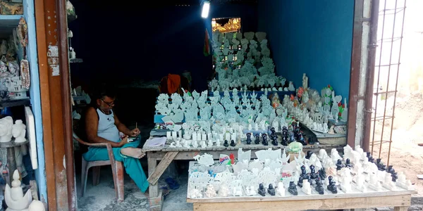 DISTRICT JABALPUR, INDIA - 17 AĞUSTOS 2019: Narmada River Caddesi 'nde misket taş heykel satan Asyalı esnaf.