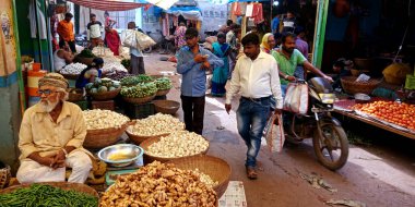 DISTRICT KATNI, INDIA - 13 Ekim 2019: Asya sokak pazarındaki sebze pazarında yürüyen bir Hint köylüsü.