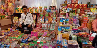DISTRICT KATNI, INDIA - 15 Ekim 2019: Geleneksel pazarda dussehra festivali sırasında müşteriye Diwali Crackers satan Hintli bir köy esnaf.