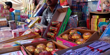 DISTRICT KATNI, INDIA - 15 Ekim 2019: Geleneksel pazarda dussehra festivalinde Diwali Crackers 'ı müşteriye sunan bir Hintli köy satıcısı.