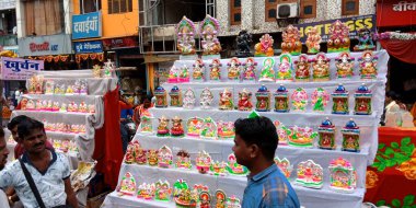 DISTRICT KATNI, INDIA - 19 Ekim 2019: Asyalı fakir erkek satıcı Hindu geleneksel diwali festivali için Lord Ganesha heykelini yerel sokak şehir pazarında satıyor.