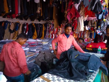 DISTRICT KATNI, INDIA - ARALIK 06, 2019: Nepalli erkek esnaflar grubu yerel şehir caddesi Çarşısı 'nda kış sezonu moda giysileri satıyor.