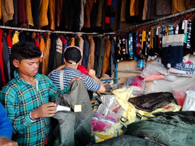 DISTRICT KATNI, INDIA - 06 Aralık 2019: Nepalli erkek esnaflar yerel sokak pazarında kış sezonu moda giysileri satıyorlar.