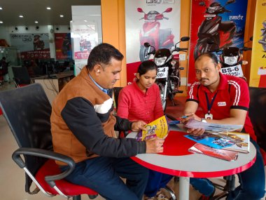 DISTRICT KATNI, INDIA - 29 HAZİRAN 2020: Kızılderili Bölgesi 'ndeki Hero otomobil motosiklet acentesinde motosiklet konuşmasında motosiklet özelliklerini açıklayan bir Asyalı Satış görevlisi.