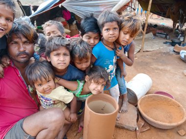 DISTRICT KATNI, INDIA - 29 HAZİRAN 2020: Ellerinin etrafında toplanan Hint köyü çocukları açık alandaki yoksul alanlarda müzik atölyesinde Drum üssü kurdular.