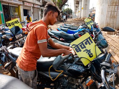 DISTRICT KATNI, INDIA - 29 HAZİRAN 2020: Hint yerlisi çocuk Asya caddesi pazarındaki teklif sırasında kullanılmış motosiklet satın alıyor.