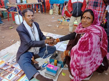 DISTRICT KATNI, INDIA - Şubat 02, 2020: Hintli köy sanatçısı Hindu geleneksel festival yaz sezonu boyunca sokak dükkanında kadına dövme yaptı.