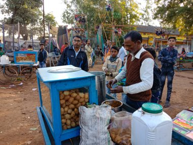 DISTRICT KATNI, INDIA - Şubat 02, 2020: Köy pazarı festivali sezonu sırasında Panipuri 'yi at arabası dükkanında yapan Hintli yaşlı bir adam.