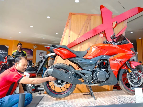 DISTRICT KATNI, INDIA - 29 HAZİRAN 2020: Asyalı ulaşım galerisinde en son Kahraman Motosiklet modelinin tekerleğini sunan Hintli bir otomobil satıcısı.