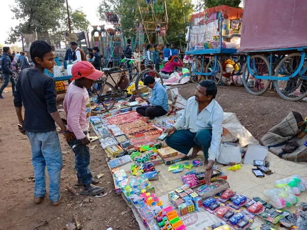 stock image DISTRICT KATNI, INDIA - FEBRUARY 02, 2020: Indian poor children looking for buying toys during festival season at local bazaar mart.