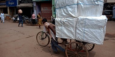 DISTRICT KATNI, INDIA - 07 Ağustos 2019: Hint triportör sürücüsü nakliye için yük vagonunu yola çekiyor.