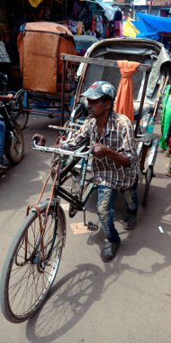 DISTRICT KATNI, INDIA - 07 Ağustos 2019: Hindistan triportör sürücüsü ağır yük çuvallarını manuel yoldan pazara doğru giden yolda taşıyor.