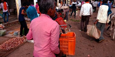 DİSTRİK KATNI, INDIA - 12 Ağustos 2019: Marketten taze yeşil tarım ürünleri aldıktan sonra sebze sandıkları yükleyen Asyalı bir adam.