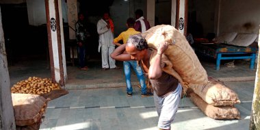 DİSTRİK KATNI, INDIA - 12 Ağustos 2019: Markette tarım ürünleri taşımak için sebze çuvalı taşıyan Asyalı bir adam.