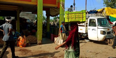 DİSTRİK KATNI, INDIA - 12 Ağustos 2019: Asyalı bir adam pazarda sebze çuvalı taşıyordu.