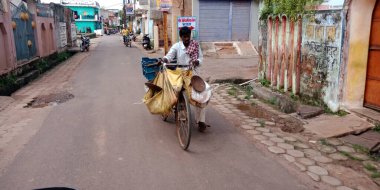 DISTRICT KATNI, INDIA - 17 Ağustos 2019: Bisikletten yeni çıkmış taze sebze satan bir Hint sokak sebzesi satıcısı.