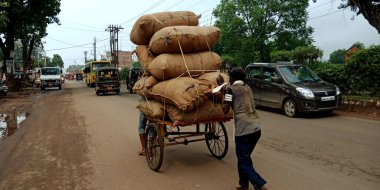 DISTRICT KATNI, INDIA - Eylül 05, 2019: Malların taşınması için yük taşıyan faytonu iten Hintli fakir bir adam.