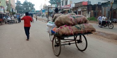 DISTRICT KATNI, Hindistan - Eylül 05, 2019: Hintli triportör şoförü yolda sebze çuvalı taşıyor.