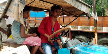 DİSTRİK KATNI, Hindistan - 12 Eylül 2019: Hintli küçük çocuk traktörü yolda sürüyor.