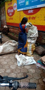 DİSTRİK KATNI, Hindistan - 12 Eylül 2019: Asyalı fakir kadın şehir temizliği amacıyla yolda çöp topluyor.