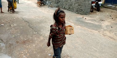 DİSTRİK KATNI, Hindistan - 12 Eylül 2019: Bir Hint köyü fakir dilenci kız elinde yiyecek kutusuyla yola çıkıyor.