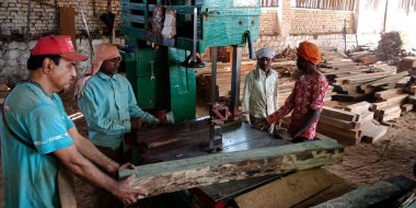 DISTRICT KATNI, INDIA - 16 Eylül 2019: Asyalı ahşap işçisi Saw Mill 'deki fabrika şantiyesinde ağaç kütükleri tutuyordu.