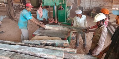 DİSTRİK KATNI, INDIA - 16 Eylül 2019: Hindistan ahşap işçisi atölyedeki elektrik makinesinden odun kesiyor.