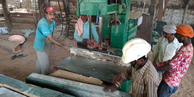 DISTRICT KATNI, INDIA - 16 Eylül 2019: Hint ahşap işçisi Saw Mill şantiyesindeki elektrik makinesinden odun kesiyor.