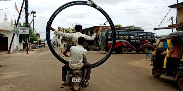 DISTRICT KATNI, INDIA - Ağustos 06, 2019: Hintliler motorsiklet taşımacılığındaki malları karayoluna doğru aşırı yüklediler.