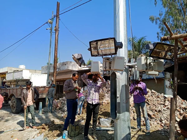 DISTRICT KATNI, INDIA - 2009 HAZİRAN 2020: Hint hükümetinin elektrik panosu elektrikçisi sokak lambalarının yenilenmesini topluyor.