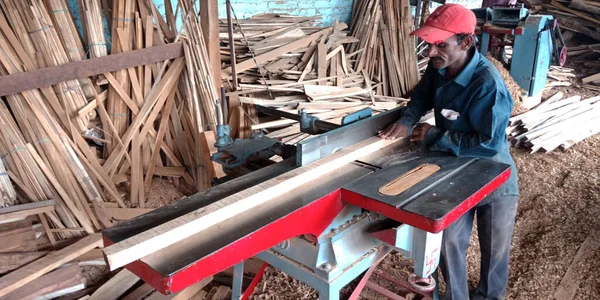 インドのディストリクト 2019年9月16日 ソーミル工場の現場で アジアの木製労働者が電気機械から木の丸太を切り取る — ストック写真