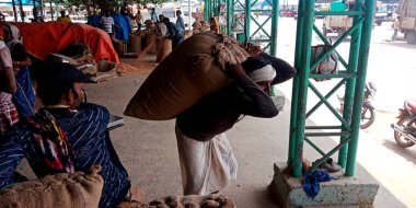 DISTRICT KATNI, INDIA - 18 Eylül 2019: Hindistan 'ın yoksul köyü buğday çuvalını Raw gıda tahıl tarım pazarında elle yapılan çalışmalardan dolayı elinde tutan olgunlaşmış işçi.