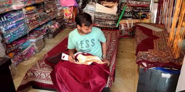 DİSTRİK KATNI, Hindistan - 18 Eylül 2019: Hintli bir erkek terzi elbise dükkanında perdeyi elle yapıyor.