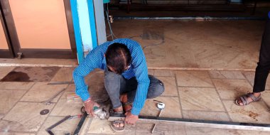 DİSTRİK KATNI, Hindistan - 18 Eylül 2019: Demir atölyesindeki çelik paneli kesen Asyalı bir demirci.