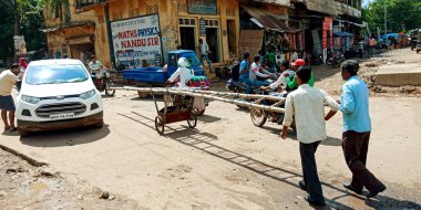 DISTRICT KATNI, INDIA - 18 Eylül 2019: Bambu merdivenlerini açık hava ortamında yol kenarına taşıyan iki Hint elektrik hattı çalışanı.