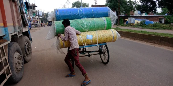 DISTRICT KATNI, INDIA - SEPTEMBER 18, 2019: An indian poor male labor pushing rickshaw on road side at outdoor environment.