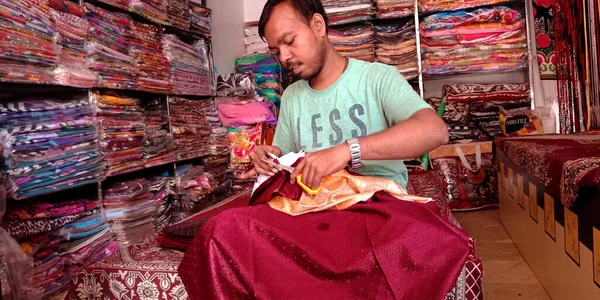 DİSTRİK KATNI, INDIA - 18 Eylül 2019: Hintli bir terzi elbise dükkanında makasın perdesini kesiyor.