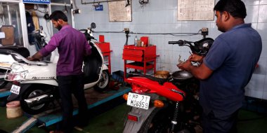 DISTRICT KATNI, INDIA - 15 Eylül 2019: Hintli otomobil atölyesinde bisiklet tamir eden Asyalı motosiklet mühendisi.