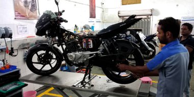 DISTRICT KATNI, INDIA - 15 Eylül 2019: Asyalı bir motosiklet tamircisi Hintli otomobil servis merkezinde bisiklet tamir eden erkek motorcu.