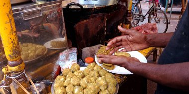 DISTRICT KATNI, Hindistan - 19 Eylül 2019: Hint sokak yemekleri satıcısı elle samosa yapıyor.