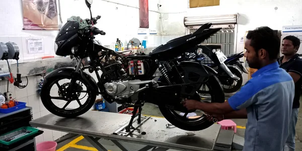 DISTRICT KATNI, INDIA - 15 Eylül 2019: Asyalı bir motosiklet tamircisi Hintli otomobil servis merkezinde bisiklet tamir eden erkek motorcu.