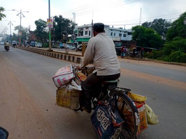 DISTRICT KATNI, Hindistan - 06 Ekim 2019: Hintli bir bisikletçi ağır malları yolda taşıyor.